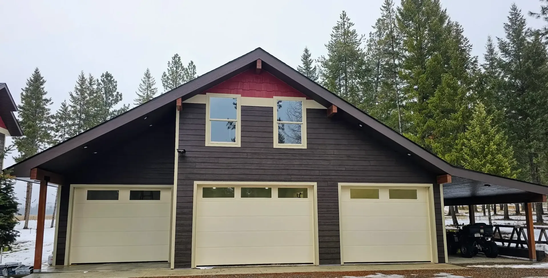 A large house with three garage doors and a large window.