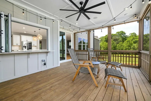 A man is sitting in a rocking chair on a porch.